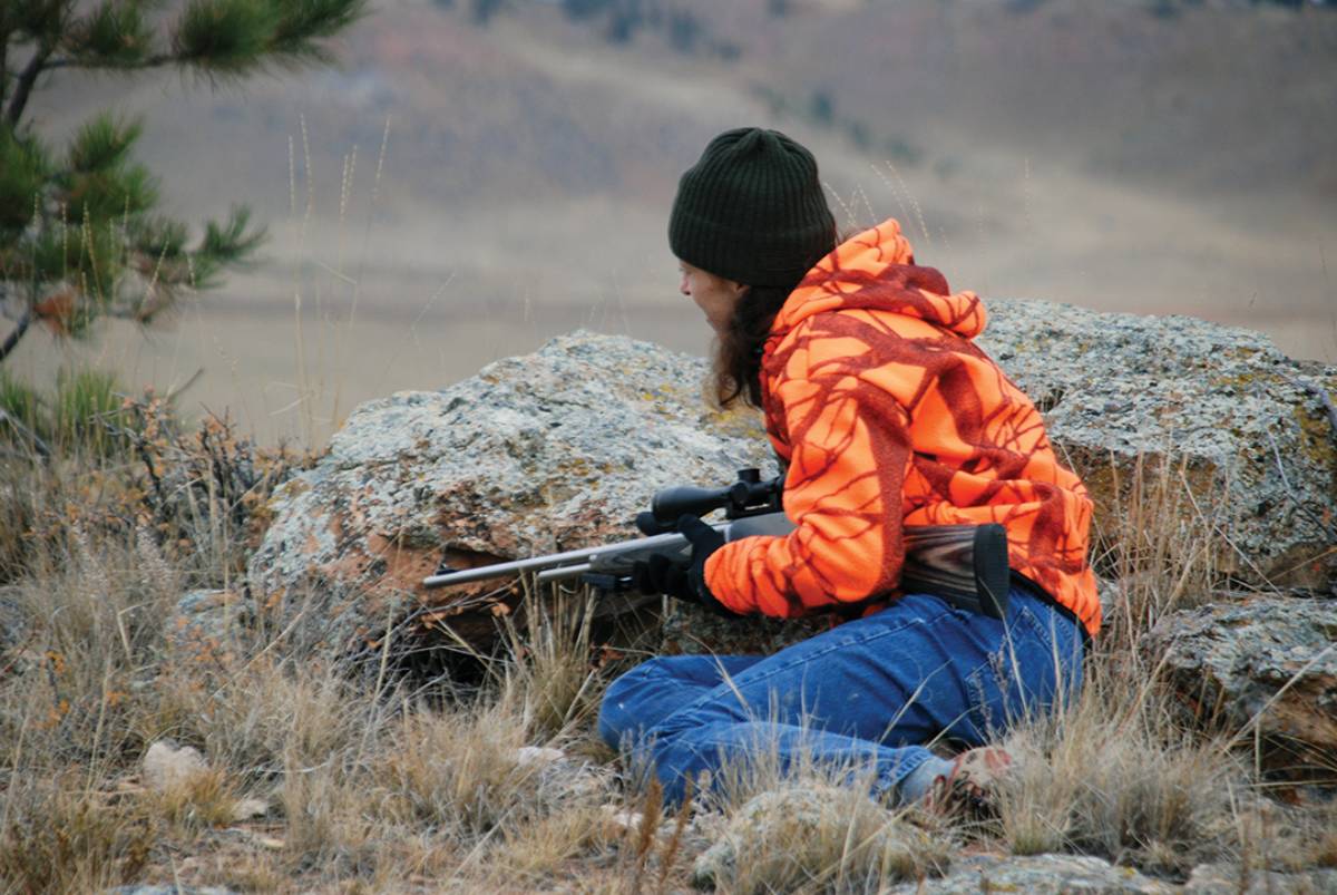 A large rock gives Lisa Ballard a good hideout while waiting to ambush pronghorn in eastern Montana.